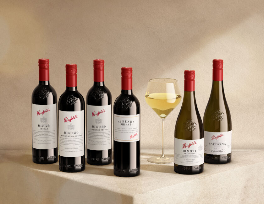 6 Penfolds wine bottles displayed with a glass of white wine 